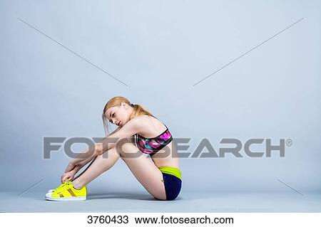Young woman sitting in keeping fitness, Profile, takes a breath View Large Photo Image Stock Image - Young woman sitting in keeping fitness, Profile, takes a breath. Fotosearch