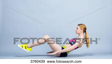 Stock Photo - Young woman sitting in keeping fitness, practical exercises. Fotosearch