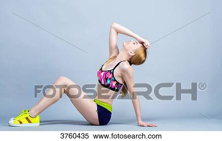 Young woman sitting, smiling, dressed in fitness, head back View Large Photo Image Stock Photography - Young woman sitting, smiling, dressed in fitness, head back. Fotosearch
