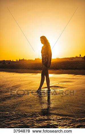 Young woman walking on the beach Praia do Barril in a sunset, deTavira city, region of Algarve, Portugal View Large Photo Image Stock Photo - Young woman walking on the beach Praia do Barril in a sunset, deTavira city, region of Algarve, Portugal. Fotosearch