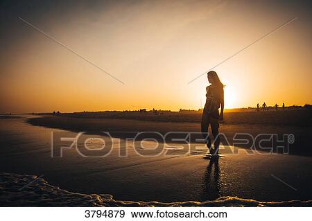 Young woman walking on the beach Praia do Barril in a sunset, deTavira city, region of Algarve, Portugal View Large Photo Image Stock Photo - Young woman walking on the beach Praia do Barril in a sunset, deTavira city, region of Algarve, Portugal. Fotosearch