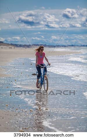 Young women riding a bike on the beach, Pas de Calais, Bitch. View Large Photo Image Picture - Young women riding a bike on the beach, Pas de Calais, Bitch.. Fotosearch