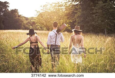 Stock Image - Youth group Hipster, back, ride in a field. Fotosearch