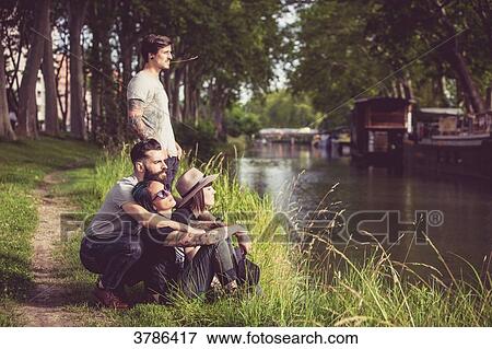 Youth group Hipster on the banks of the Garonne, barges in the background View Large Photo Image Stock Photo - Youth group Hipster on the banks of the Garonne, barges in the background. Fotosearch
