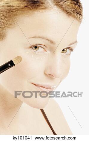 Young Woman face making-up with eyeshadow, drops of cream under her eye, close-up (studio) View Large Photo Image Stock Image - Young Woman face making-up with eyeshadow, drops of cream under her eye, close-up (studio). Fotosearch