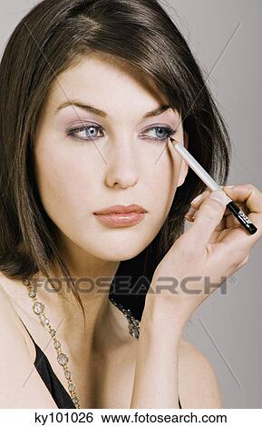 Young Woman face making-up with eyeliner, close-up (studio) View Large Photo Image Stock Photograph - Young Woman face making-up with eyeliner, close-up (studio). Fotosearch