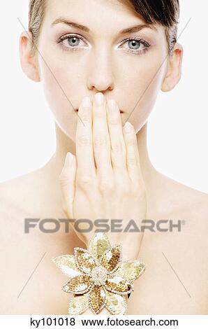 Young Woman face with make up, having her hand in front of her mouth, close-up (studio) View Large Photo Image Stock Photo - Young Woman face with make up, having her hand in front of her mouth, close-up (studio). Fotosearch