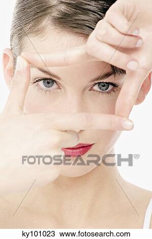 Young Woman face with make up, looking at the camera, making a frame with her fingers, close-up (studio) View Large Photo Image Stock Image - Young Woman face with make up, looking at the camera, making a frame with her fingers, close-up (studio). Fotosearch