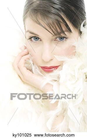 Young Woman face with make up, lookint at the camera, with feather collar, close-up (studio) View Large Photo Image Stock Photography - Young Woman face with make up, lookint at the camera, with feather collar, close-up (studio). Fotosearch