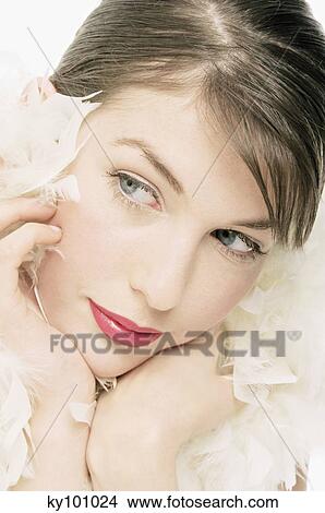 Picture - Young Woman face with make up, with feather collar, close-up (studio). Fotosearch