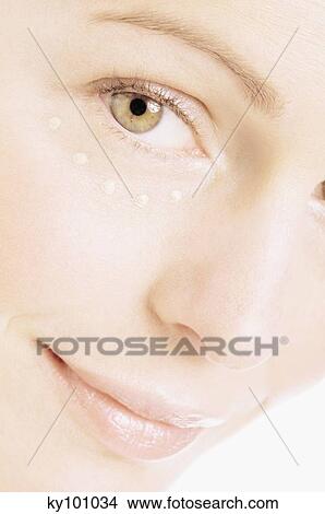 Young Woman face with make up, with drops of cream under her eye, close-up (studio) View Large Photo Image Picture - Young Woman face with make up, with drops of cream under her eye, close-up (studio). Fotosearch