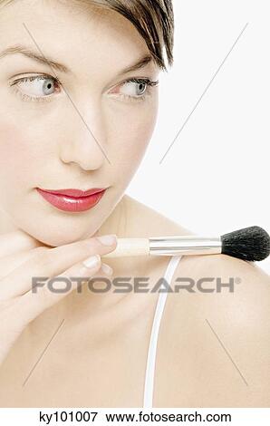 Young Woman with Make-Up holding a brush, close-up (studio) View Large Photo Image Stock Photo - Young Woman with Make-Up holding a brush, close-up (studio). Fotosearch