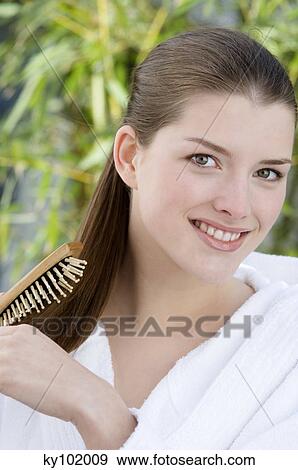 Woman brushing hair, inside View Large Photo Image Stock Photo - Woman brushing hair, inside. Fotosearch