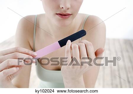 Woman filing her nails, inside, close up View Large Photo Image Picture - Woman filing her nails, inside, close up. Fotosearch