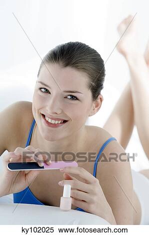 Woman filing her nails, inside View Large Photo Image Stock Photography - Woman filing her nails, inside. Fotosearch