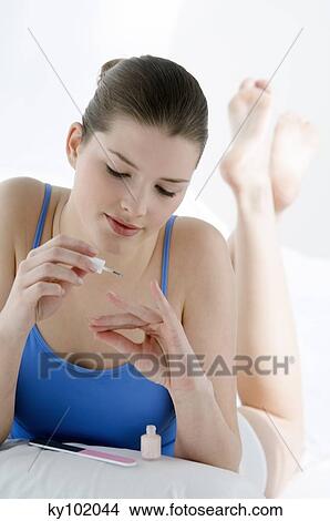 Woman painting her nails, inside View Large Photo Image Picture - Woman painting her nails, inside. Fotosearch