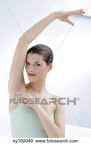Stock Photo - Woman using deodorant, inside (studio). Fotosearch