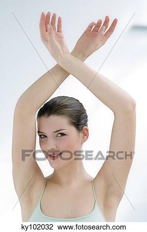 Stock Image - Woman with her arms in the air (studio). Fotosearch