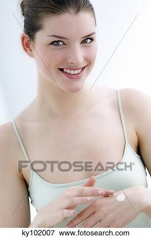 Young Woman applying moisturizer to hand (studio) View Large Photo Image Stock Photo - Young Woman applying moisturizer to hand (studio). Fotosearch