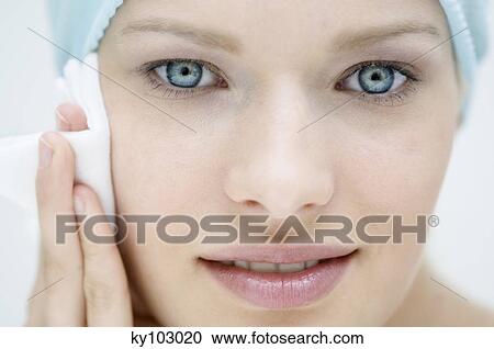 Young Woman face using a cleansing cotton on her cheek, close-up (studio) View Large Photo Image Stock Image - Young Woman face using a cleansing cotton on her cheek, close-up (studio). Fotosearch
