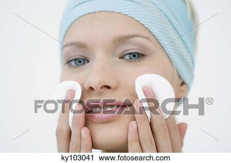 Young Woman face using a cleansing cotton on her cheeks, close-up (studio) View Large Photo Image Stock Image - Young Woman face using a cleansing cotton on her cheeks, close-up (studio). Fotosearch