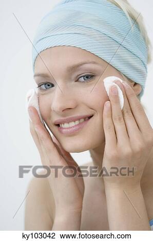 Young Woman face using a cleansing cotton on her cheeks, close-up (studio) View Large Photo Image Stock Image - Young Woman face using a cleansing cotton on her cheeks, close-up (studio). Fotosearch