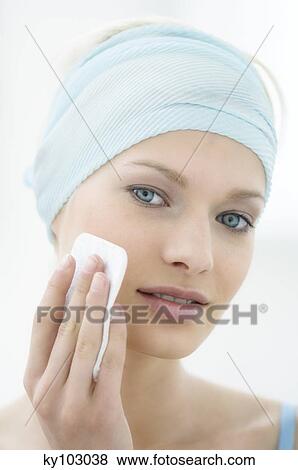 Young Woman face using a cleansing cotton on her cheek, close-up (studio) View Large Photo Image Stock Photo - Young Woman face using a cleansing cotton on her cheek, close-up (studio). Fotosearch