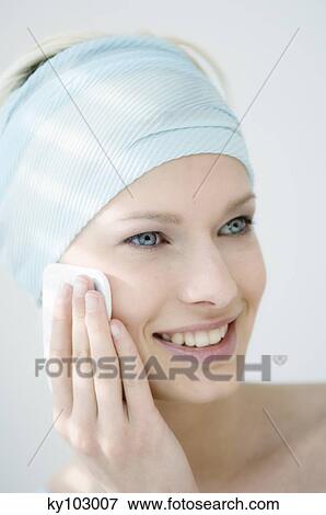 Young Woman face with make up, holding a cleansing cotton on her cheek (studio) View Large Photo Image Stock Photo - Young Woman face with make up, holding a cleansing cotton on her cheek (studio). Fotosearch
