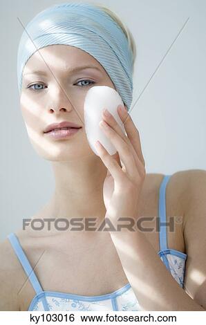 Young Woman face with make up, holding a bath sponge on her cheek (studio) View Large Photo Image Stock Photograph - Young Woman face with make up, holding a bath sponge on her cheek (studio). Fotosearch