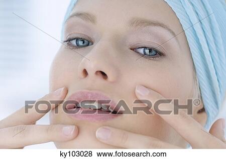 Young Woman face with make up, looking at the camera, fingers on her face, close-up (studio) View Large Photo Image Stock Photo - Young Woman face with make up, looking at the camera, fingers on her face, close-up (studio). Fotosearch