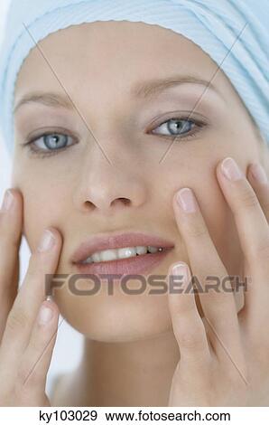 Young Woman face with make up, looking at the camera, fingers on her face, close-up (studio) View Large Photo Image Stock Photo - Young Woman face with make up, looking at the camera, fingers on her face, close-up (studio). Fotosearch
