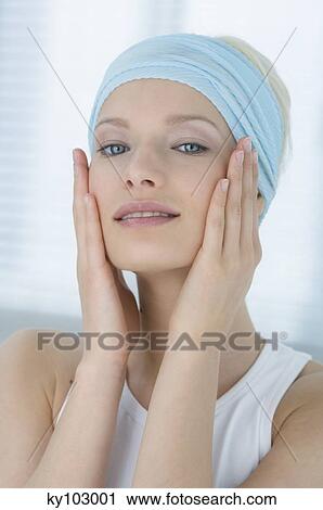 Young Woman looking at the camera, putting her hands on her cheeks close-up (studio) View Large Photo Image Stock Image - Young Woman looking at the camera, putting her hands on her cheeks close-up (studio). Fotosearch