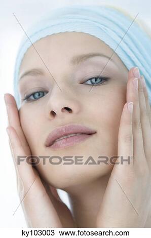 Young Woman looking at the camera, putting her hands on her cheeks close-up (studio) View Large Photo Image Stock Image - Young Woman looking at the camera, putting her hands on her cheeks close-up (studio). Fotosearch