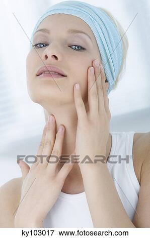 Young Woman looking at the camera, putting her hands on her neck close-up (studio) View Large Photo Image Stock Photo - Young Woman looking at the camera, putting her hands on her neck close-up (studio). Fotosearch