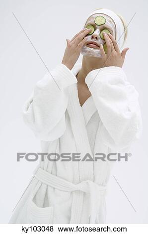 Young woman with beauty mask on her face and slices cucumber on her eyes View Large Photo Image Stock Photo - Young woman with beauty mask on her face and slices cucumber on her eyes. Fotosearch