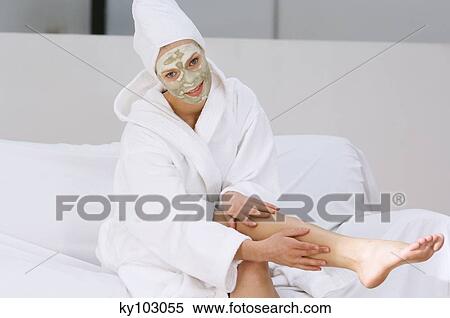 Young woman with beauty mask on her face, massaging her leg View Large Photo Image Stock Photography - Young woman with beauty mask on her face, massaging her leg. Fotosearch