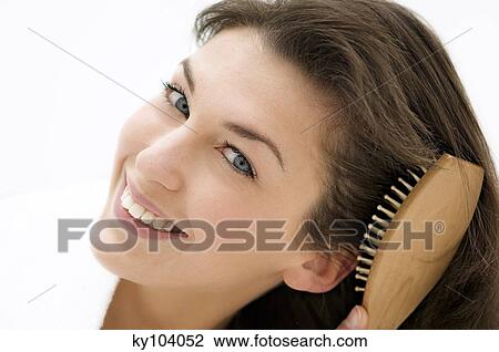 Portrait of a young woman brushing her hair View Large Photo Image Stock Image - Portrait of a young woman brushing her hair. Fotosearch