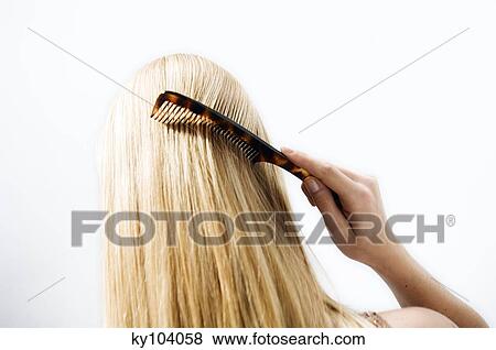 Portrait of a young woman combing her hair, view from the back View Large Photo Image Stock Photo - Portrait of a young woman combing her hair, view from the back. Fotosearch