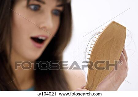 Portrait of a young woman holding a hairbrush View Large Photo Image Stock Image - Portrait of a young woman holding a hairbrush. Fotosearch