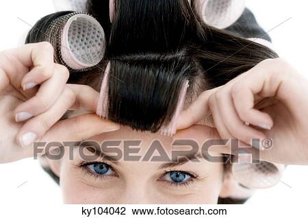 Stock Image - Portrait of a young woman in curlers, close up (studio). Fotosearch