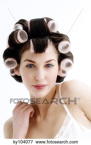 Stock Photo - Portrait of a young woman in curlers, close up (studio). Fotosearch