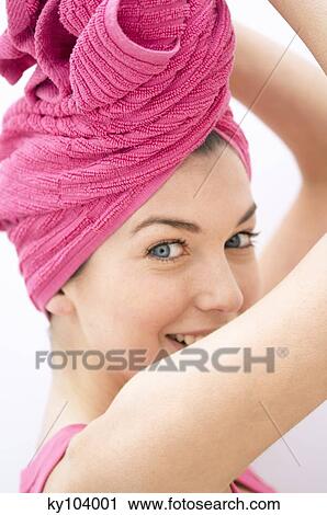 Portrait of a young woman looking at the camera, pink hand towel on her head View Large Photo Image Stock Image - Portrait of a young woman looking at the camera, pink hand towel on her head. Fotosearch