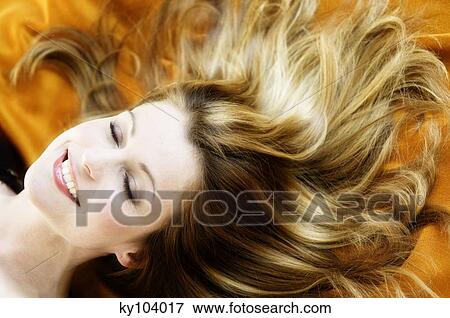 Portrait of a young woman lying, long hair on yellow textil fabric View Large Photo Image Stock Photo - Portrait of a young woman lying, long hair on yellow textil fabric. Fotosearch