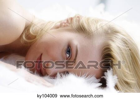 Stock Photo - Portrait of a young woman lying on a shag carpet. Fotosearch