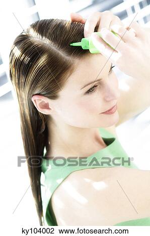 Portrait of a young woman pouring on hair lotion on her head View Large Photo Image Stock Image - Portrait of a young woman pouring on hair lotion on her head. Fotosearch