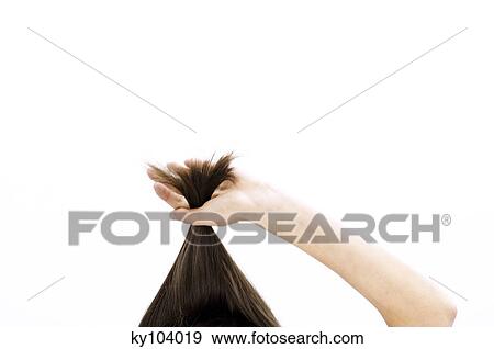 Portrait of a young woman pulling her hair, close up (studio) View Large Photo Image Stock Photo - Portrait of a young woman pulling her hair, close up (studio). Fotosearch