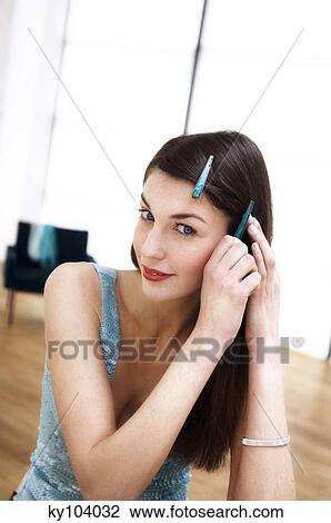 Portrait of a young woman putting a slide in her hair View Large Photo Image Stock Image - Portrait of a young woman putting a slide in her hair. Fotosearch