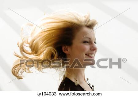 Stock Image - Portrait of a young woman smilng, blond hair, blurred motion. Fotosearch