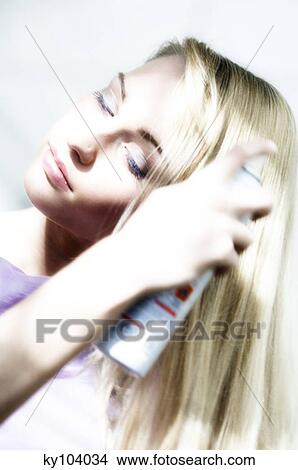 Portrait of a young woman using hair spray View Large Photo Image Picture - Portrait of a young woman using hair spray. Fotosearch