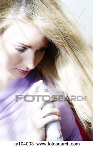 Portrait of a young woman using hair spray View Large Photo Image Stock Image - Portrait of a young woman using hair spray. Fotosearch